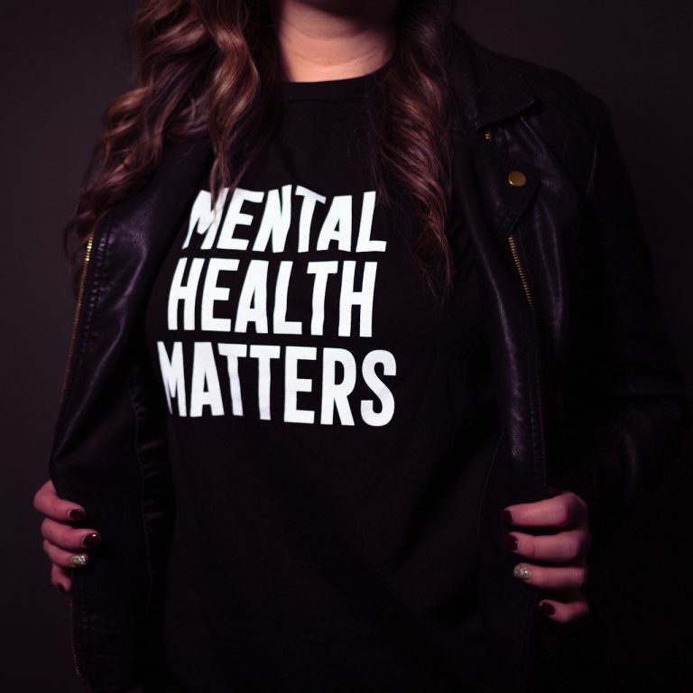 Una persona lleva una camiseta negra con el texto "Mental Health Matters".